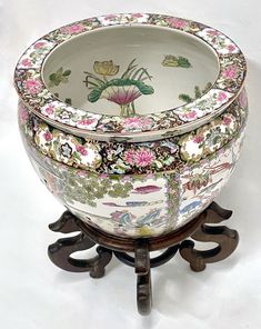 an ornately decorated bowl sitting on top of a wooden stand