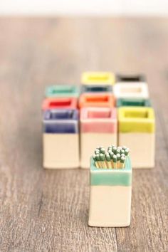 several small colorful toothbrush holders sitting on top of a wooden table next to each other