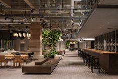 an empty restaurant with tables, chairs and planters on the wall behind the bar