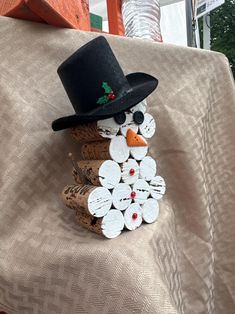 a snowman made out of wine corks sitting on top of a tablecloth