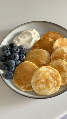 pancakes with blueberries and whipped cream on a plate