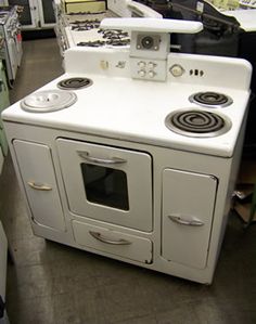 a white stove top oven sitting inside of a kitchen next to cabinets and counter tops