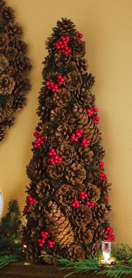 two pine cones on top of a mantel decorated with holly berries and red berries