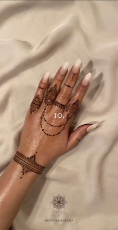 a woman's hand with henna tattoos on it and the words 10 written in arabic