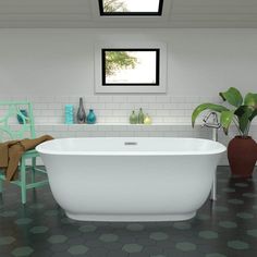 a white bath tub sitting in a bathroom next to a green chair and potted plant