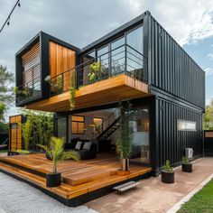 a house made out of shipping containers with wooden floors and balconies on the roof