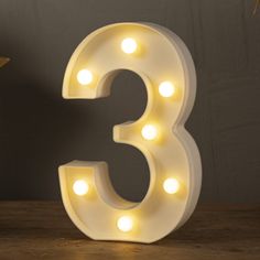 the number three light up sign is sitting on a table