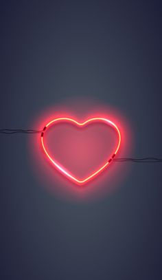 a heart shaped neon sign hanging from a wire