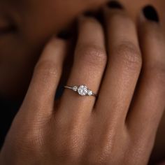 a woman's hand with a diamond ring on it