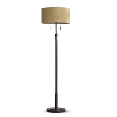 a floor lamp with a beige shade on the base and a black metal pole underneath it