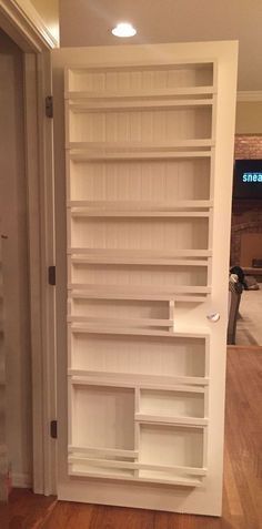 an empty white bookcase in the corner of a room