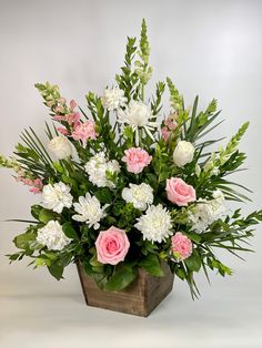 a wooden vase filled with white and pink flowers