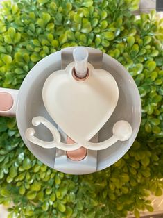 an overhead view of a cup with two spoons in it and a heart on the top