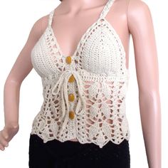 a mannequin wearing a white crochet top and black shorts with buttons