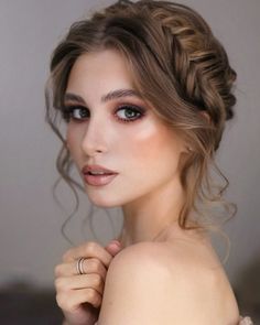 a woman with braid hair and ring on her left hand posing for the camera, wearing an off shoulder dress