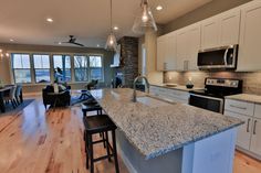 a large kitchen with an island in the middle and lots of counter space on one side