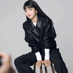 a woman sitting on top of a wooden chair