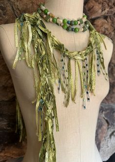 Light green scarf for women. Moss green ribbon scarf made of beautiful soft ribbon with metallic yarn running through it and accented with metallic ladder yarn. Makes different  gift for women who has everything. Works great on St.Patrick's Day, you will pass wearing green that day.   This is about 65" long traditional scarf with firm body.  Hand wash in lukewarm water with mild soap, don't rub or wring, squeeze of excess water and hang to dry.  Comes with nice organza satchel for traveling or gift giving. I recommend storing the ribbon scarves by hanging or flat in a drawer.  Handmade in United States of America.  Visit the store front at  www.Etsy.com/shop/thinkerbella for more color and design options.  Colors may vary slightly due to different monitor resolutions. If in doubt or have a Festive Green Bohemian Scarves, Handmade Green Scarf As A Gift, Ladder Yarn, Ribbon Scarf, Green Accessories, Summer Scarf, Scarf Necklace, Fiber Jewelry, Fabric Necklace