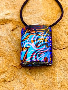 This piece is part of my newest series I've called The Looking Glass Series.  I am in love with how these have turned out and hope that you find them beautiful as well.  This is a stunning dichroic glass pendant featuring orange flames with a background of blue smoke.  The colors in this piece shift depending on the angle the pendant is viewed from.  Handmade in my home glass studio using fusible glass.  Each piece in this series are layered and have a lot of depth.  Due to the color/texture var Modern Multicolor Glass Jewelry, Modern Rectangular Glass Jewelry, Unique Rectangular Glass Jewelry, Fused Glass Jewelry Dichroic, Dichroic Jewelry, Dichroic Glass Jewelry, Dichroic Pendant, Dichroic Glass Pendant, Fused Glass Pendant