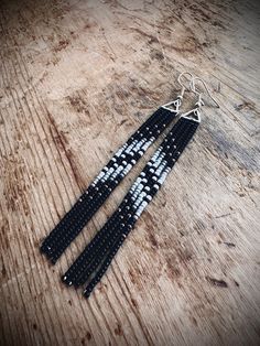 These light weight earrings are 4 inches long and made to order. shades of gray and black. Black And White Seed Bead Earrings, Handmade Gray Dangle Earrings, Handmade Gray Beaded Dangle Earrings, Handmade Gray Drop Earrings, Black Dangle Linear Earrings For Pierced Ears, Black Beaded Long Drop Earrings, Black Long Drop Beaded Earrings For Gift, Handmade Black Long Drop Earrings, Handmade Black Beaded Long Drop Earrings