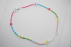 a colorful beaded necklace on a white surface