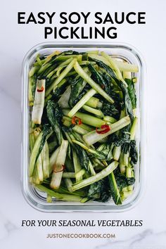 a container filled with green vegetables on top of a white counter