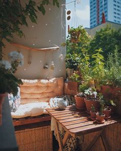 an outdoor patio with potted plants on the table and in the background is a cityscape