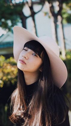 a woman with long hair wearing a white hat