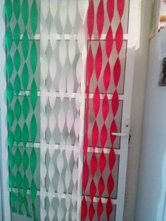 a white door with red and green designs on the front, behind it is a refrigerator