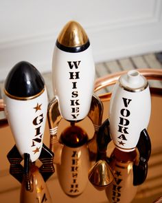 three white and black rockets sitting on top of a gold tray next to each other