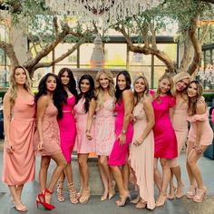 a group of women standing next to each other in front of a chandelier