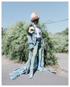 a man dressed in an old fashion outfit with feathers on his head and sunflowers