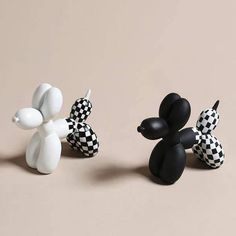 three black and white figurines sitting on top of a table next to each other