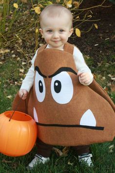 a young child dressed in a costume holding a pumpkin and wearing a face on it