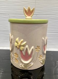 a ceramic planter sitting on top of a black table next to a white wall