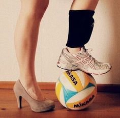 a woman standing on top of a soccer ball next to her foot wearing high heels