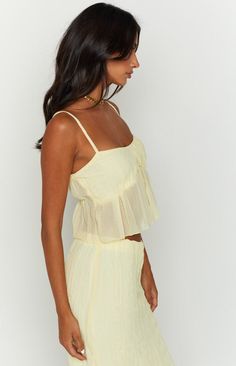 * Yellow Cami Top  
 * Major summer vibes! Pair this cute cami crop top () with the matching maxi skirt (), or with shorts () for a more relaxed look.  
 * 
 
 * Cropped style  
 * Adjustable spaghetti straps  
 * Flowy style 
 * Lined bust 
 * Sheer below bust 
 * Light weight material 
 * Sleeveless Flowy Style, Prom Midi Dress, Tank Crop Top, Vest Crop Top, Summer Playsuit, Women Y2k, Semi Formal Dresses, Strapless Tops, Cami Crop Top