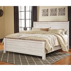 a white bed sitting on top of a wooden floor