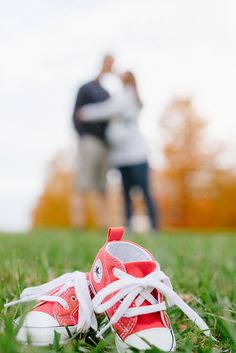 two people standing in the grass with their feet up