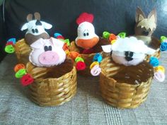 three stuffed animals sitting in baskets on a couch