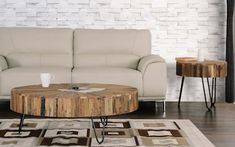 a living room with a couch, coffee table and two end tables in front of a white brick wall