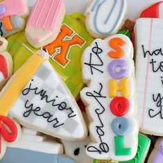 decorated cookies with writing and school supplies are displayed in a white box on top of each other