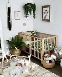 a baby crib in a white room with potted plants and other decorations on the wall