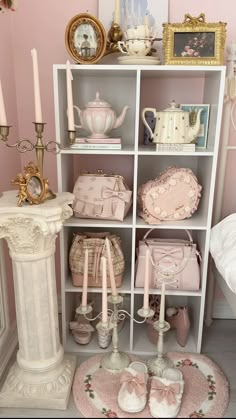 a white shelf filled with lots of pink purses and other items on top of it