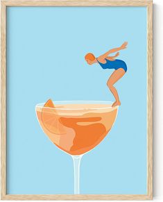 a woman in blue swimsuit standing on the edge of a glass filled with orange liquid