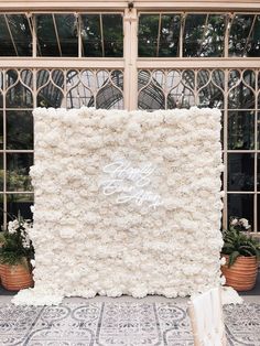 a large white flowered wall in front of a building