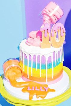 a rainbow cake with icing and decorations on it