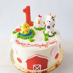 a birthday cake decorated with farm animals and the number one on it's top