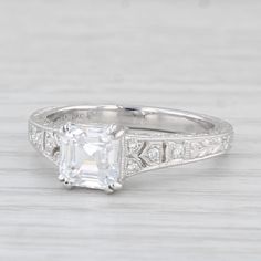 an antique style engagement ring with a princess cut diamond in the center