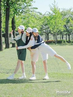 three young women are posing for a photo in the grass with one woman holding another